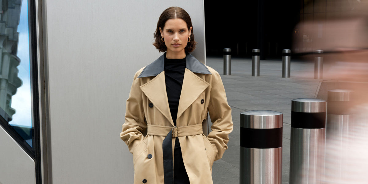 Brunette woman posing in a camel trench coat