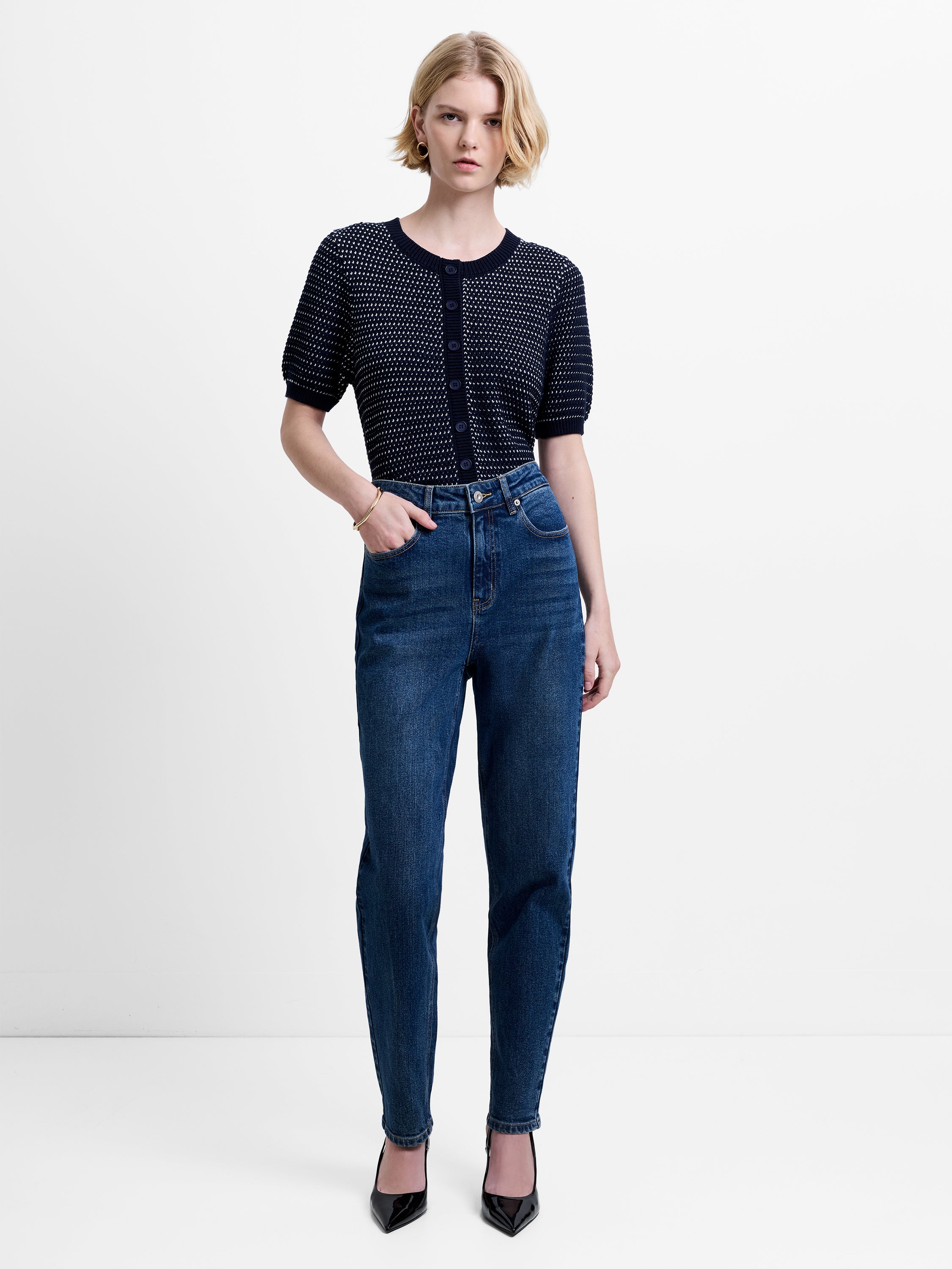 Woman wearing dark blue, slim straight leg jeans with a high waisted fit