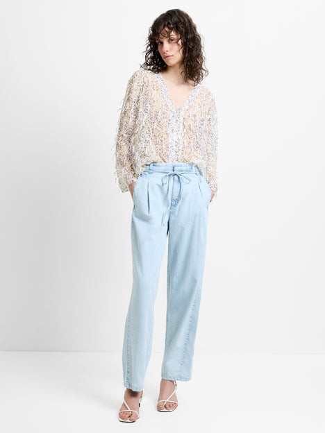 Woman wearing light blue tapered fit jeans with a tie waist