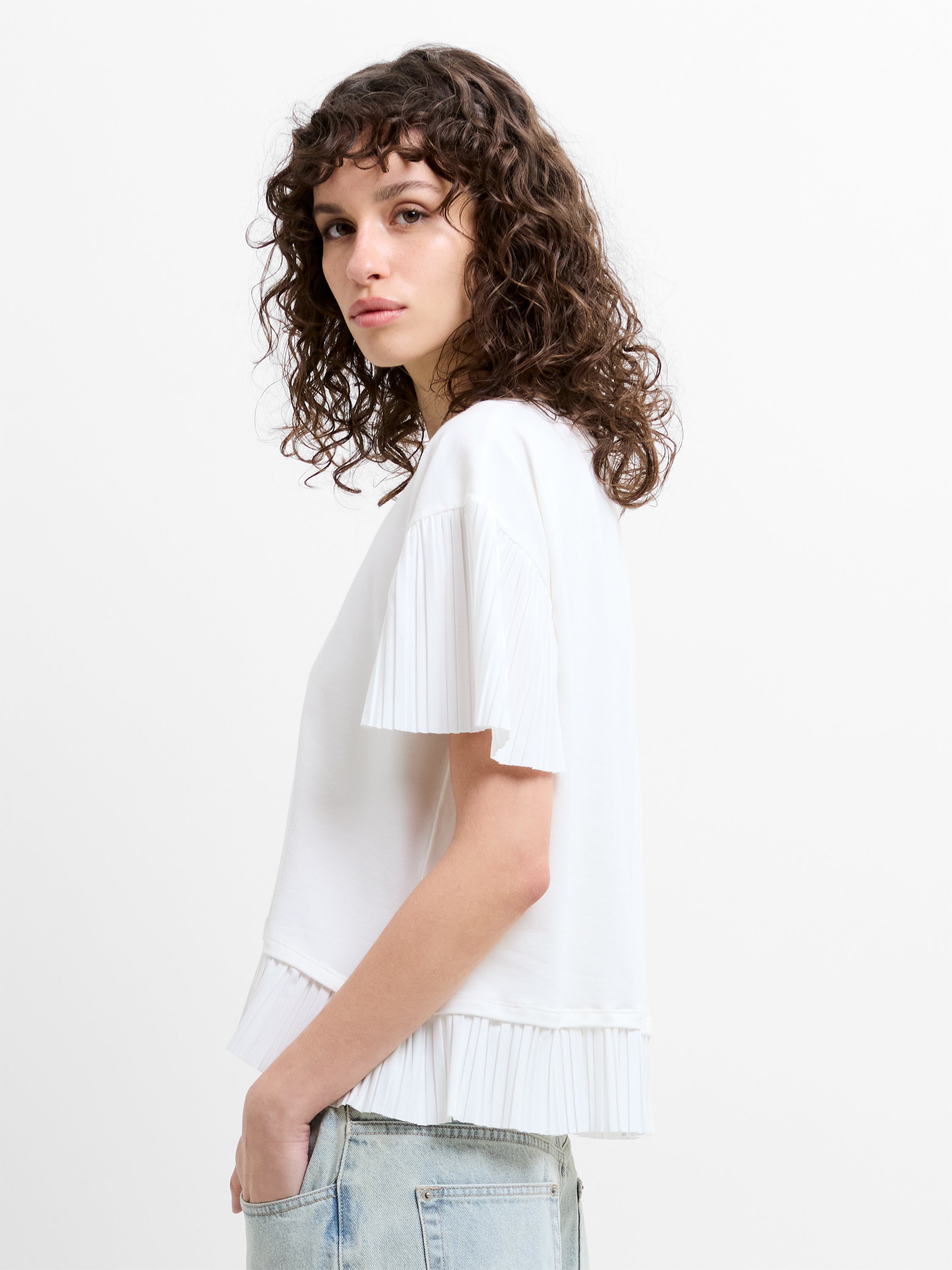 Woman wearing a white plisse trim short sleeve T-shirt